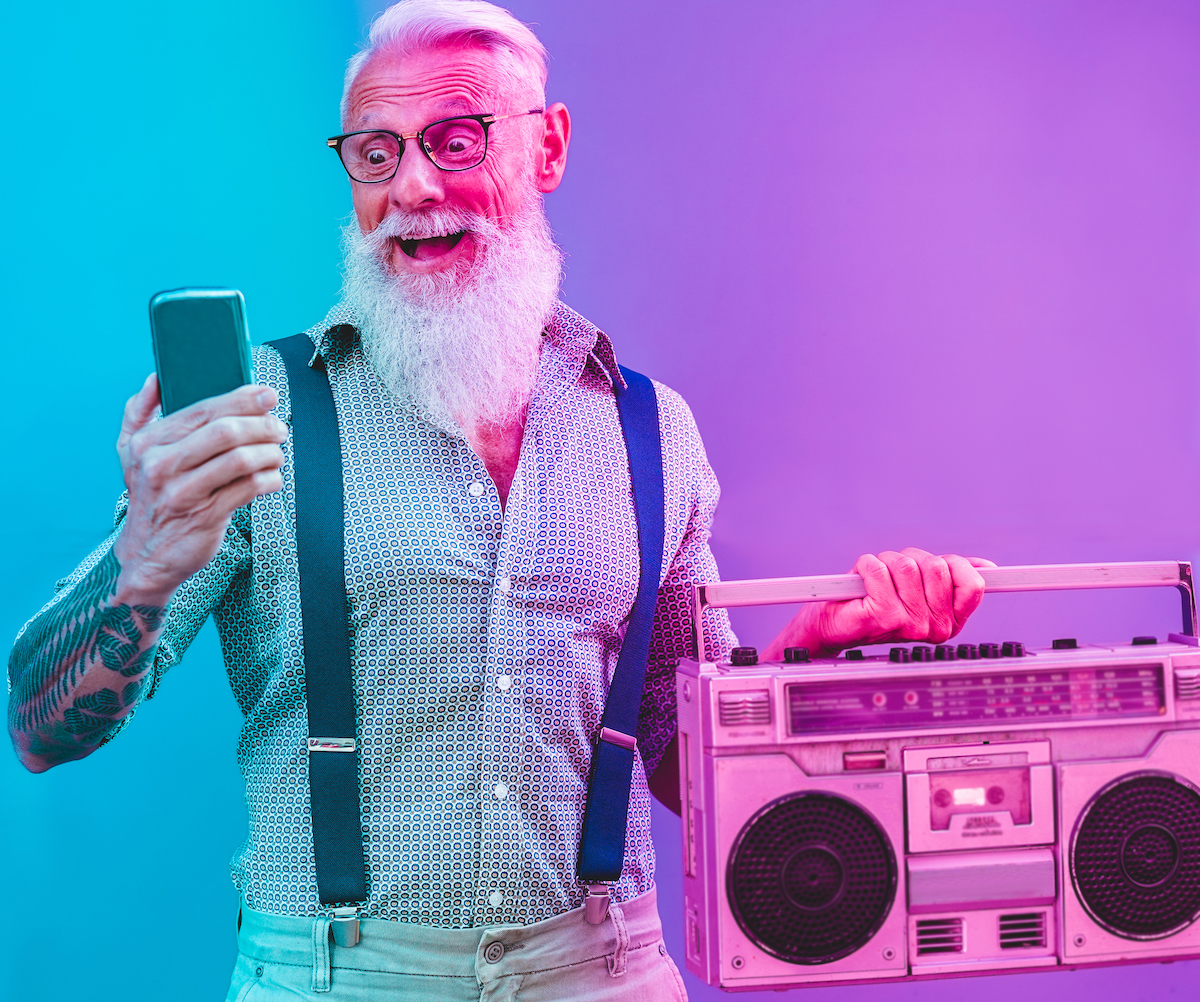 Senior hipster man using smartphone app for creating playlist – Trendy tattoo guy having fun with mobile phone technology – Tech and joyful elderly lifestyle concept – Radial purple and blue filter