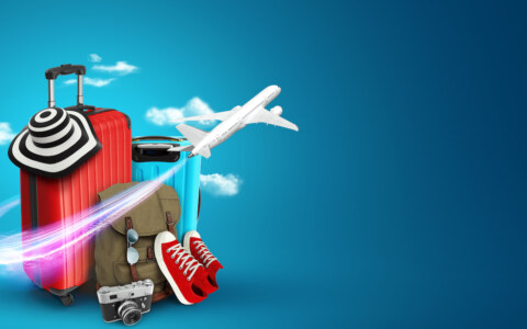 Creative background, red suitcase, sneakers, plane on a blue background.
